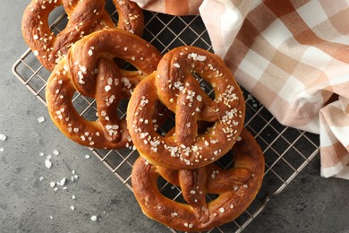 Photo of Tasty pretzels with salt on grey table, top view