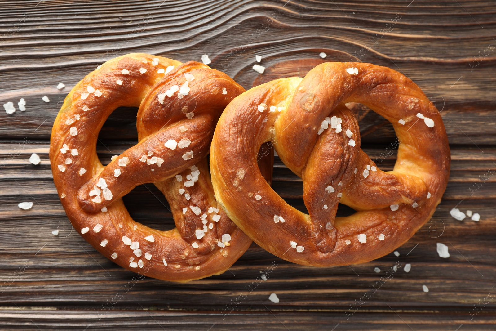 Tasty pretzels with salt on wooden table, flat lay Photo of Tasty pretzels with salt on wooden table, flat lay