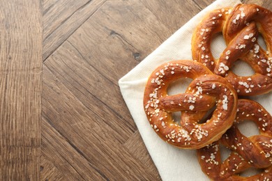 Photo of Tasty pretzels with salt on wooden table, flat lay. Space for text