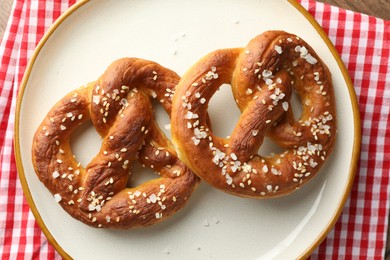 Photo of Tasty pretzels with salt on table, top view
