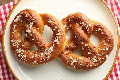 Photo of Tasty pretzels with salt on table, top view