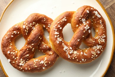 Photo of Tasty pretzels with salt on table, top view