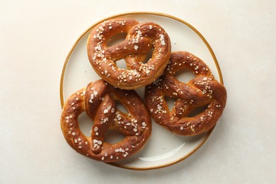 Photo of Tasty pretzels with salt on white table, top view