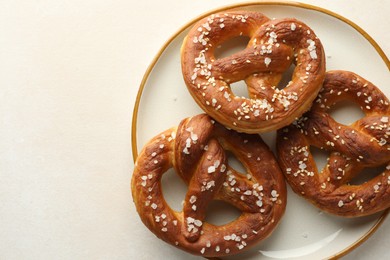 Photo of Tasty pretzels with salt on white table, top view. Space for text