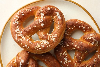 Photo of Tasty pretzels with salt on white table, top view
