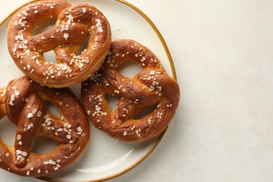 Photo of Tasty pretzels with salt on white table, top view. Space for text