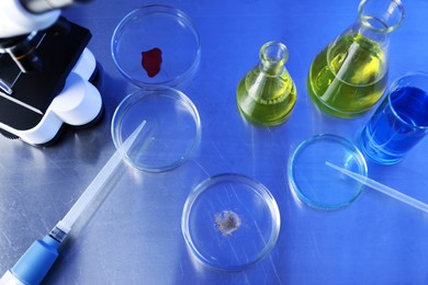 Photo of Petri dishes, pipettes and flasks with samples on table, above view