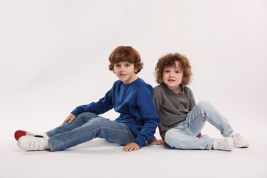 Photo of Cute little brothers posing on white background