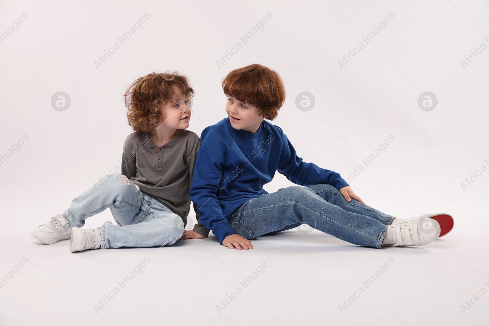 Cute little brothers posing on white background Photo of Cute little brothers posing on white background
