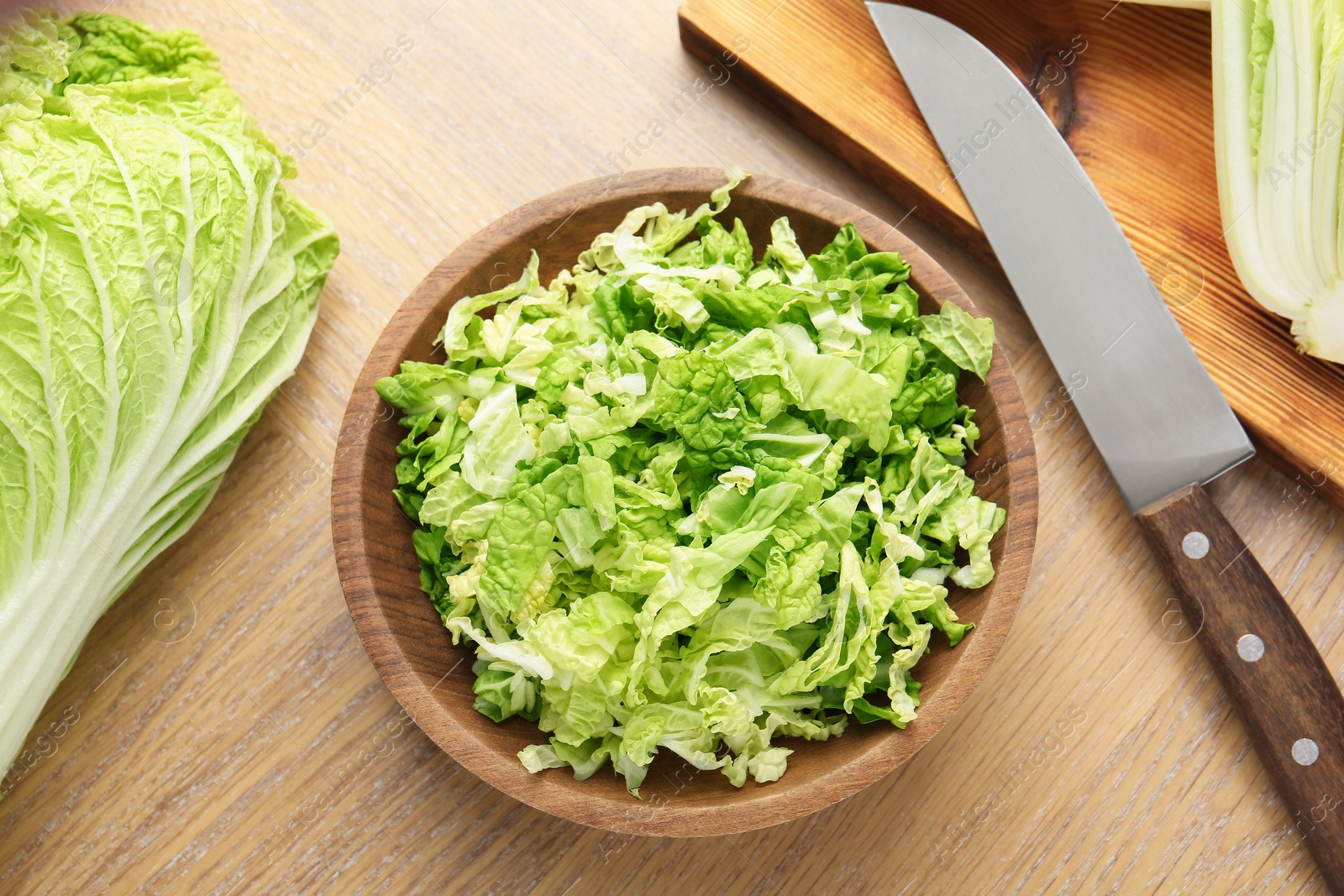 Fresh Chinese cabbages and knife on wooden table, flat lay Photo of Fresh Chinese cabbages and knife on wooden table, flat lay