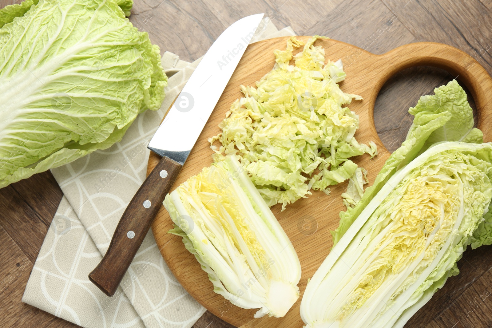 Fresh Chinese cabbages and knife on wooden table, flat lay Photo of Fresh Chinese cabbages and knife on wooden table, flat lay