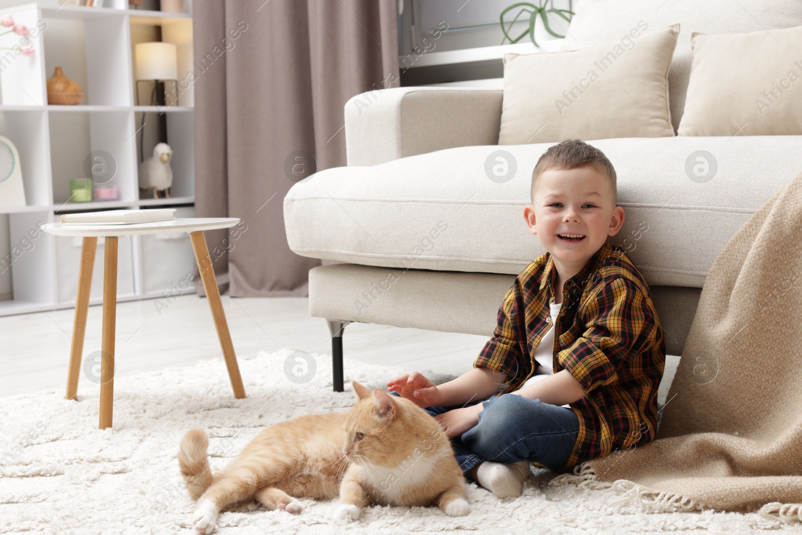 Little boy with his cute ginger cat at home, space for text Photo of Little boy with his cute ginger cat at home, space for text