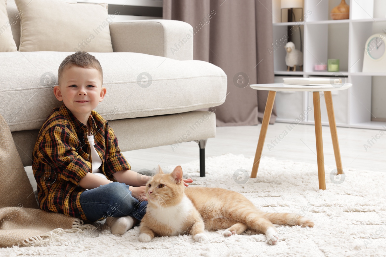 Little boy with his cute ginger cat at home, space for text Photo of Little boy with his cute ginger cat at home, space for text
