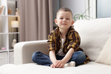 Photo of Cute little boy on sofa at home