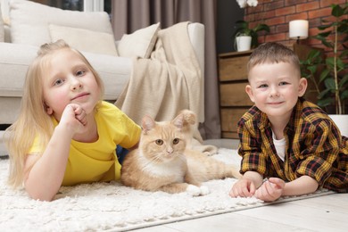 Photo of Little kids with their cute ginger cat at home