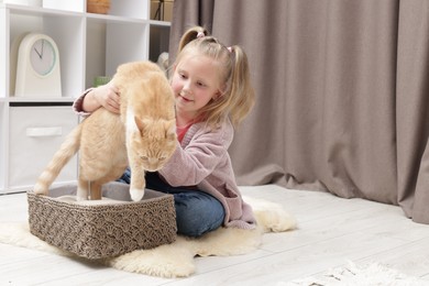 Photo of Little girl with her cute ginger cat at home, space for text
