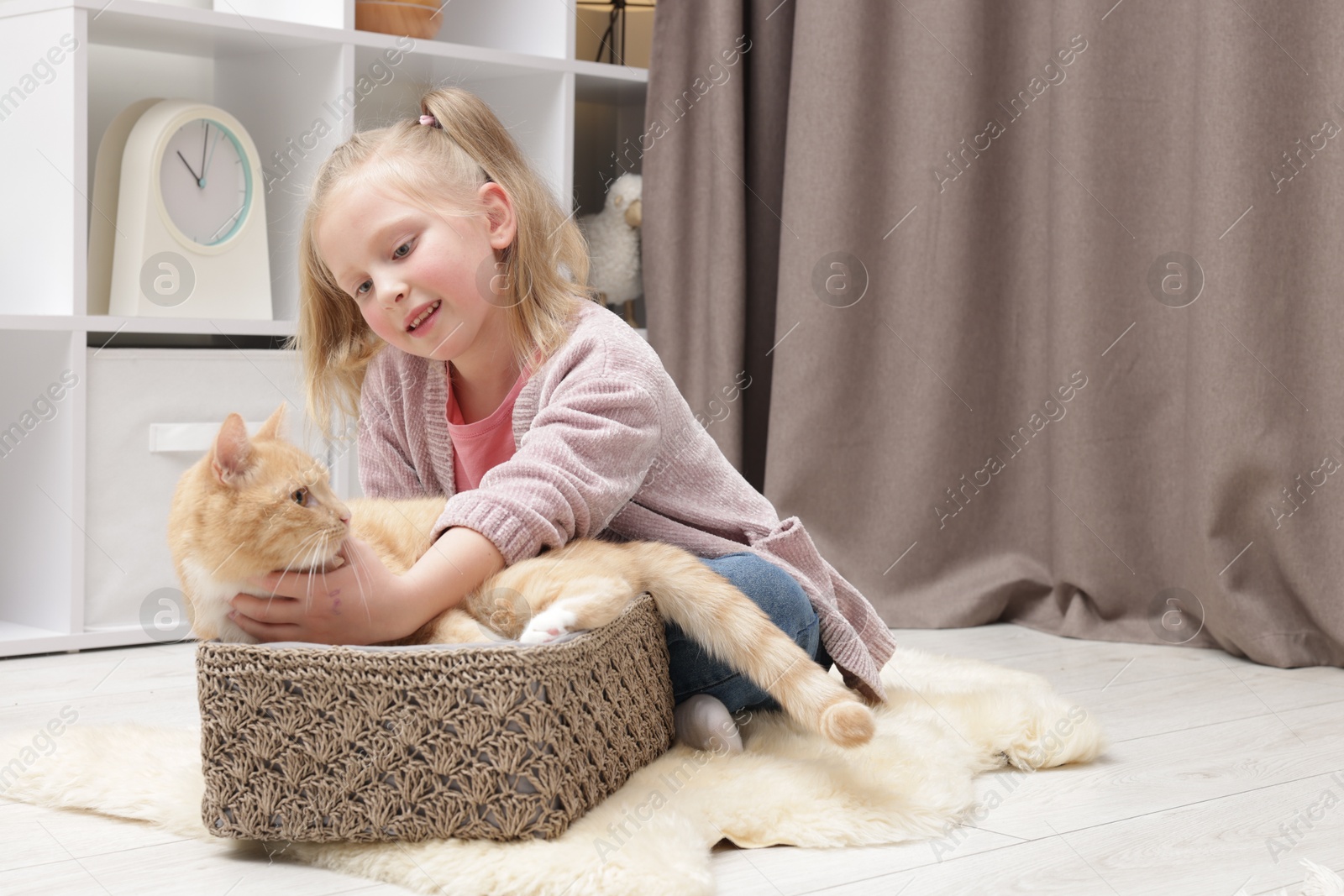 Little girl with her cute ginger cat at home, space for text Photo of Little girl with her cute ginger cat at home, space for text