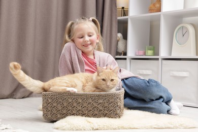 Photo of Little girl with her cute ginger cat at home
