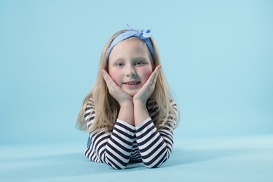 Photo of Cute little girl on light blue background