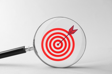 Image of Targeting. Magnifying glass with bullseye inside on light background, closeup