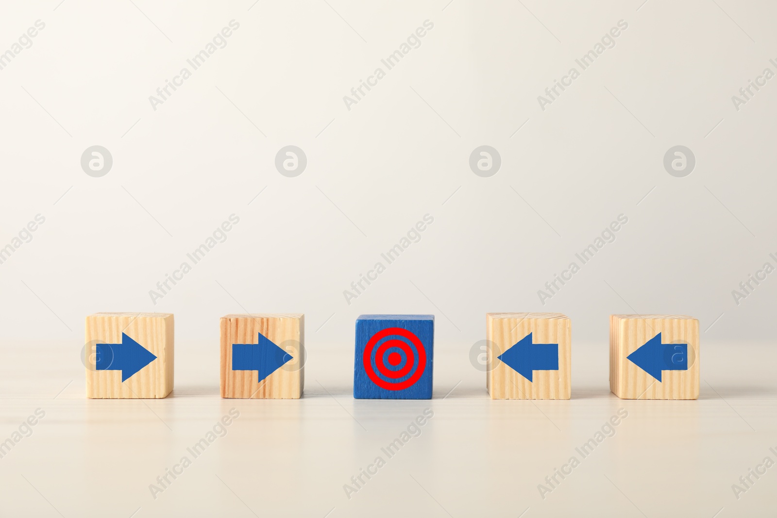 Targeting. Wooden cubes with arrows pointing at blue one with bullseye on table Image of Targeting. Wooden cubes with arrows pointing at blue one with bullseye on table