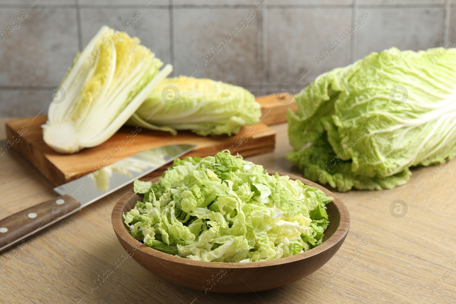 Fresh Chinese cabbages and knife on wooden table, closeup Photo of Fresh Chinese cabbages and knife on wooden table, closeup