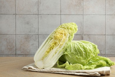 Photo of Fresh Chinese cabbages on wooden table, space for text