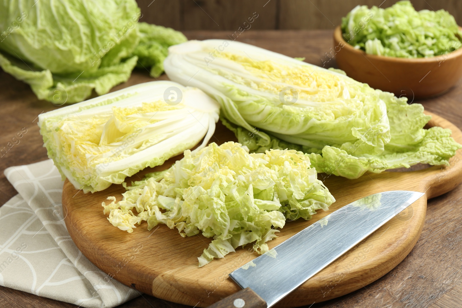 Fresh Chinese cabbages and knife on wooden table, closeup Photo of Fresh Chinese cabbages and knife on wooden table, closeup