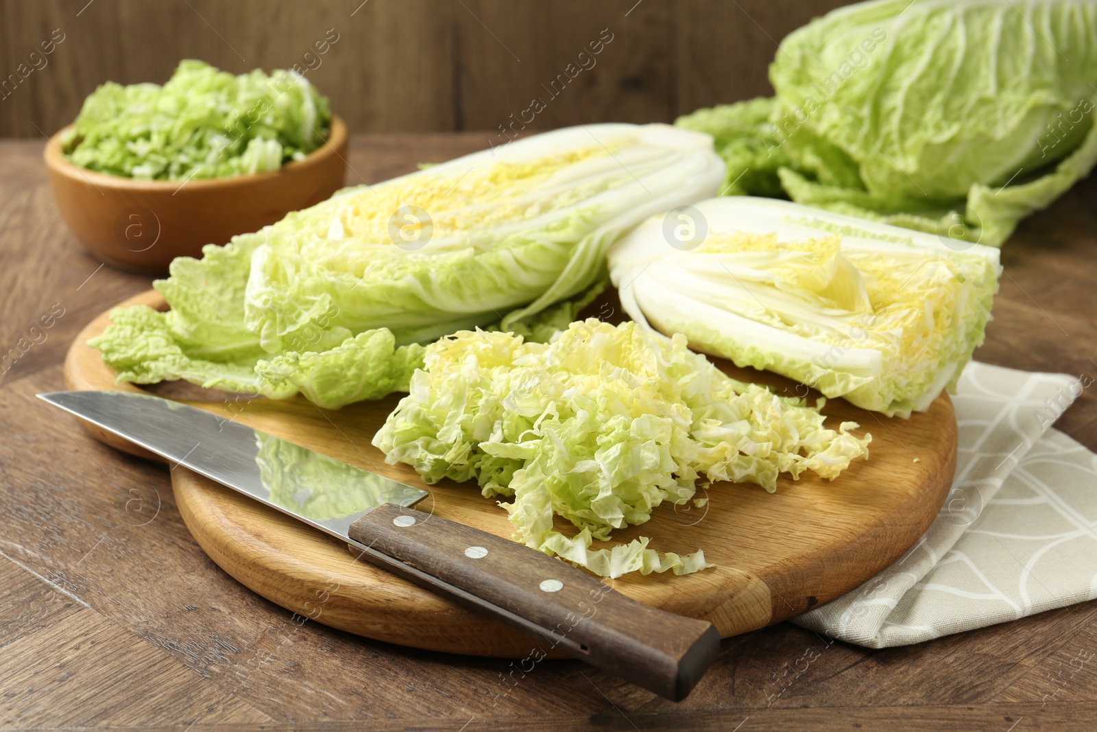 Fresh Chinese cabbages and knife on wooden table, closeup Photo of Fresh Chinese cabbages and knife on wooden table, closeup