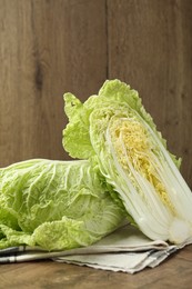 Photo of Fresh Chinese cabbages on wooden table, closeup