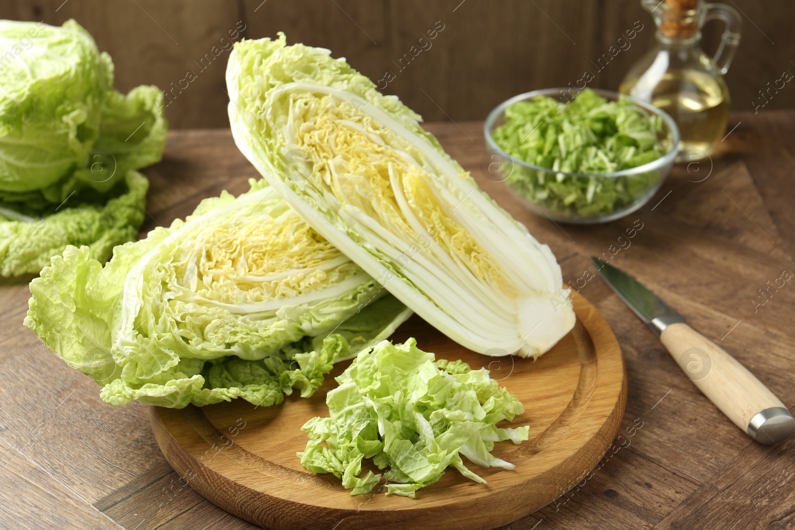 Fresh cut Chinese cabbage and knife on wooden table Photo of Fresh cut Chinese cabbage and knife on wooden table