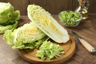 Photo of Fresh cut Chinese cabbage and knife on wooden table