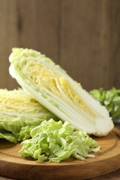 Photo of Fresh cut Chinese cabbage on wooden table, closeup