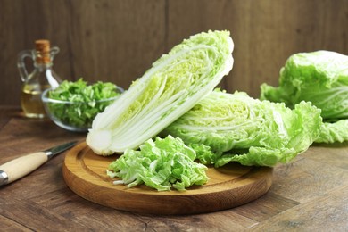 Photo of Fresh cut Chinese cabbage and knife on wooden table