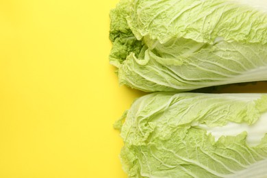Photo of Fresh Chinese cabbages on yellow background, top view. Space for text
