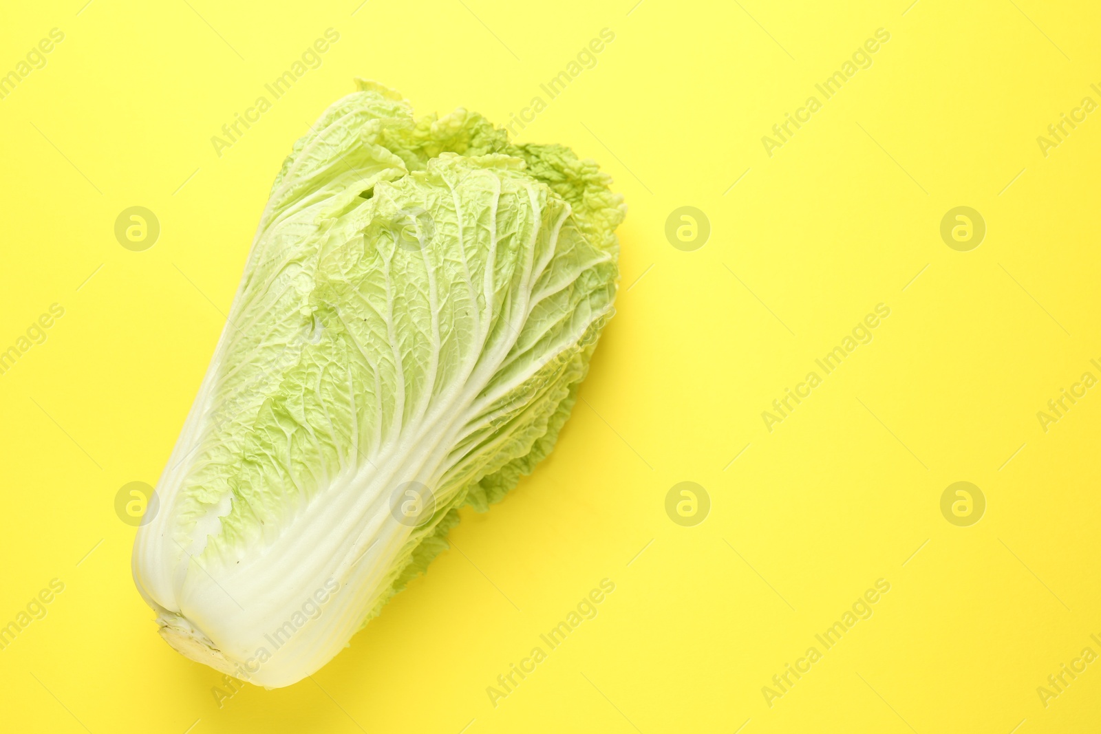 Fresh Chinese cabbage on yellow background, top view. Space for text Photo of Fresh Chinese cabbage on yellow background, top view. Space for text