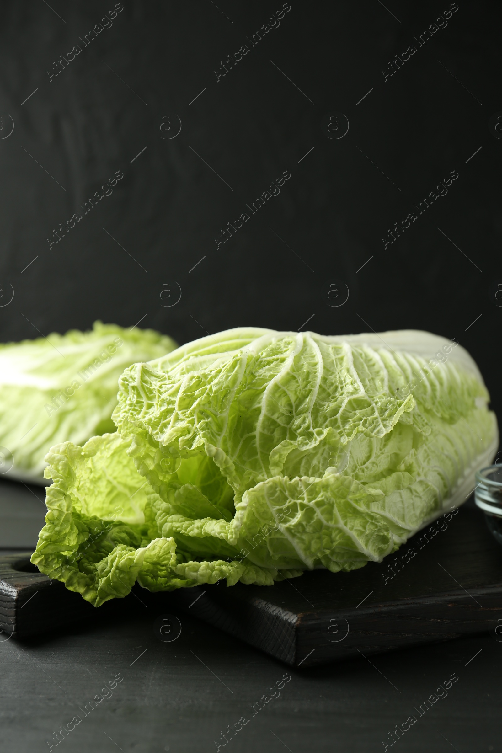 Fresh Chinese cabbages on black wooden table, closeup. Space for text Photo of Fresh Chinese cabbages on black wooden table, closeup. Space for text