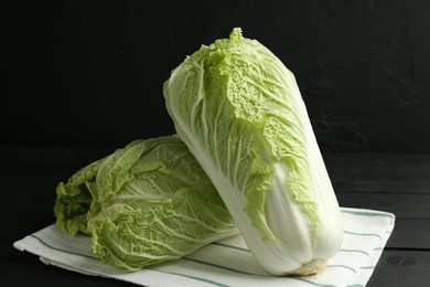 Photo of Fresh Chinese cabbages on black wooden table