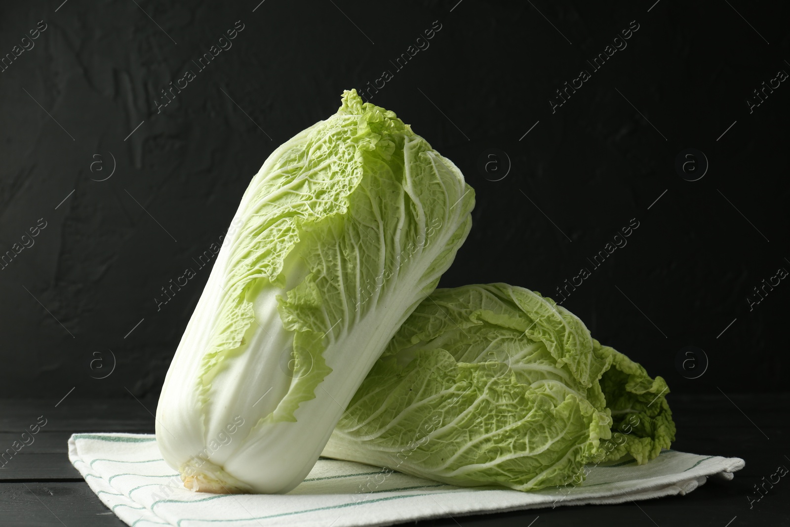 Fresh Chinese cabbages on black wooden table Photo of Fresh Chinese cabbages on black wooden table