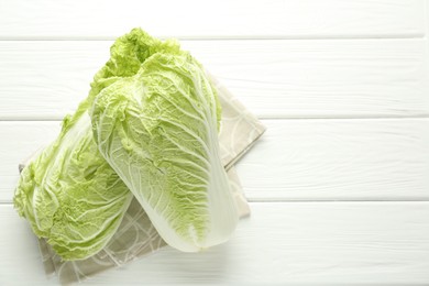 Photo of Fresh Chinese cabbages on white wooden table, top view. Space for text