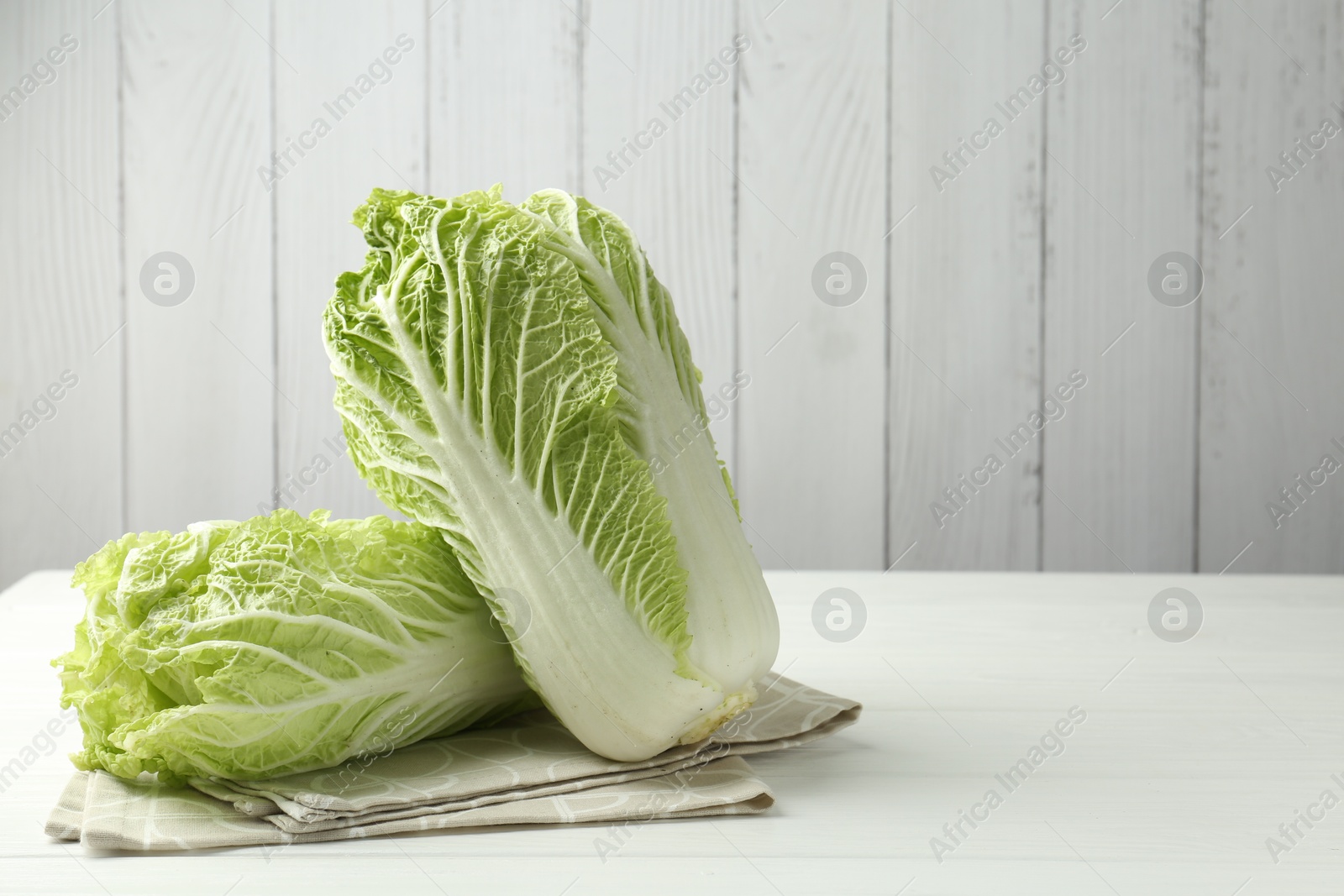 Fresh Chinese cabbages on white wooden table, space for text Photo of Fresh Chinese cabbages on white wooden table, space for text