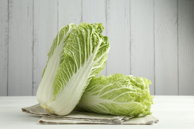 Photo of Fresh Chinese cabbages on white wooden table