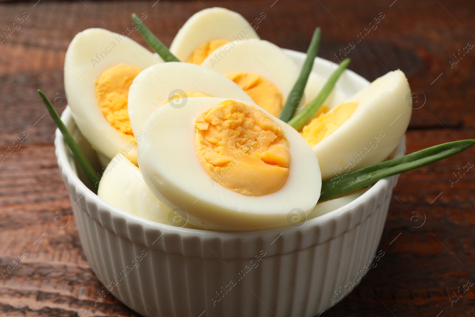 Boiled eggs and green onions on wooden table, closeup Photo of Boiled eggs and green onions on wooden table, closeup