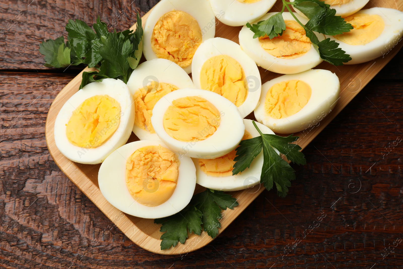 Boiled eggs and parsley on wooden table, top view Photo of Boiled eggs and parsley on wooden table, top view