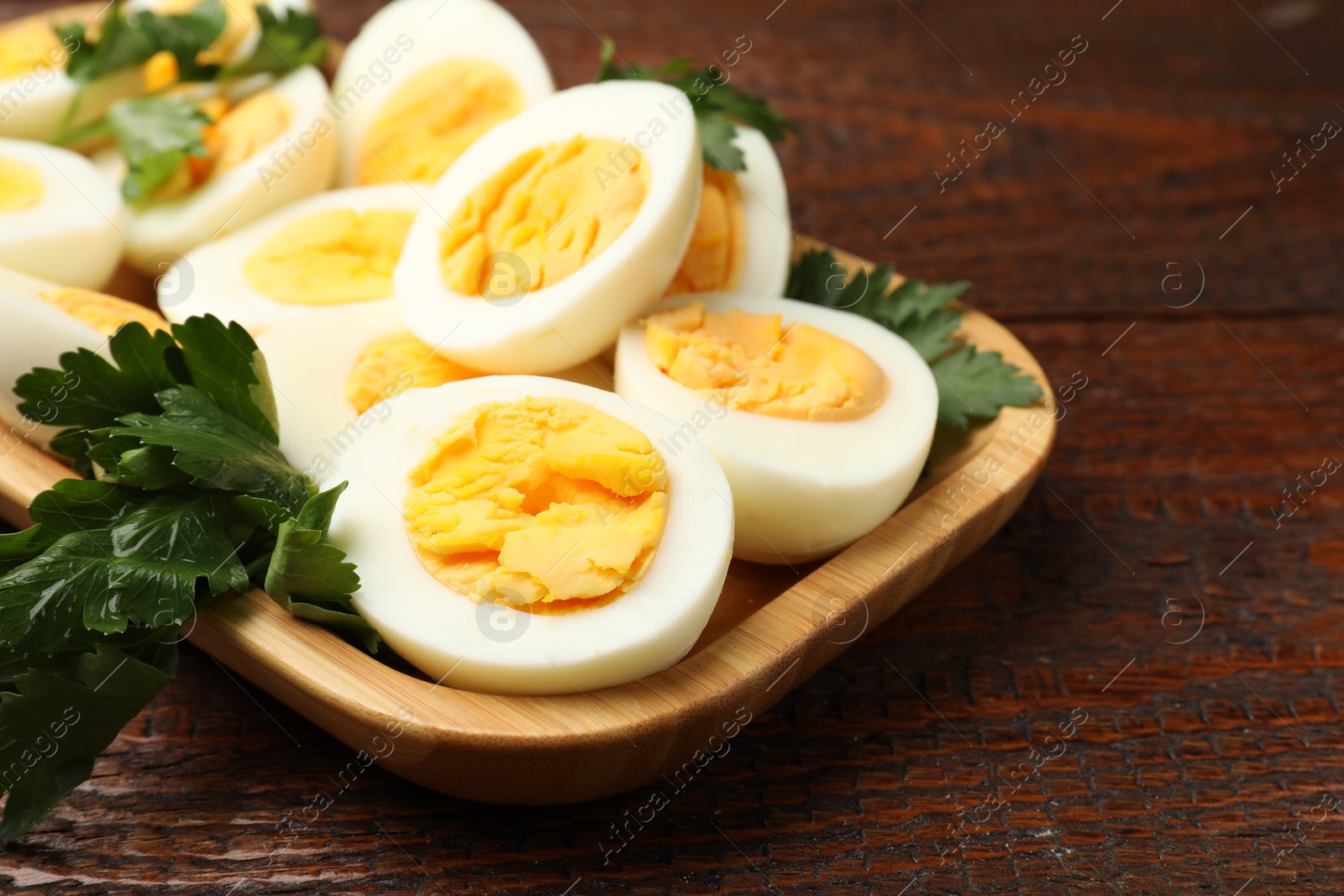 Boiled eggs and parsley on wooden table, closeup Photo of Boiled eggs and parsley on wooden table, closeup