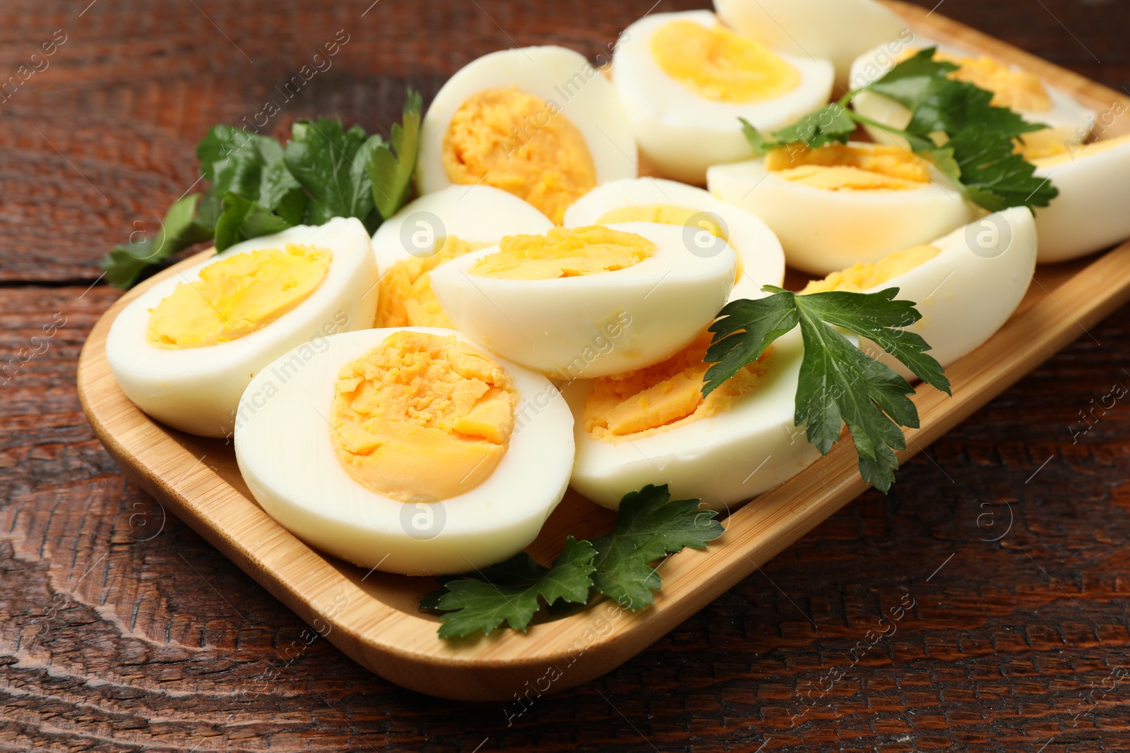 Boiled eggs and parsley on wooden table, closeup Photo of Boiled eggs and parsley on wooden table, closeup