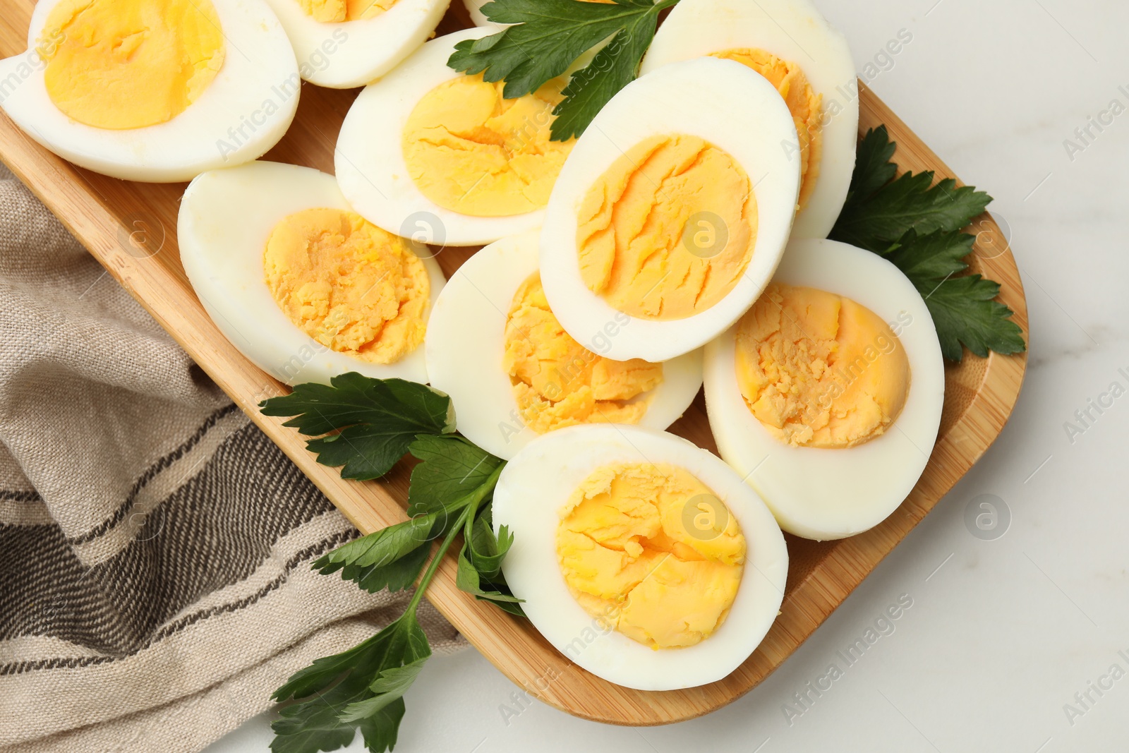 Boiled eggs and parsley on white marble table, top view Photo of Boiled eggs and parsley on white marble table, top view