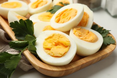 Photo of Boiled eggs and parsley on white table, closeup
