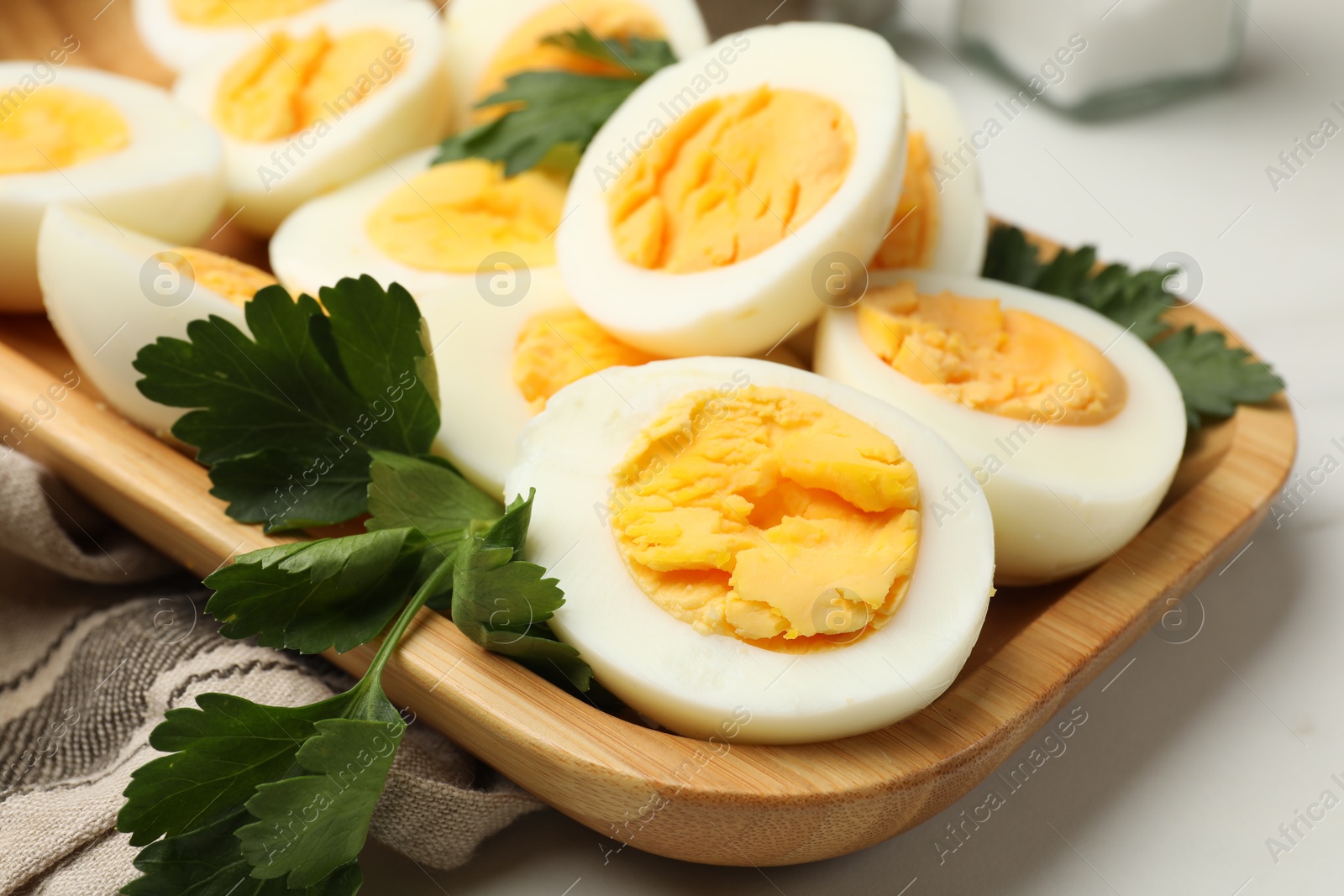 Boiled eggs and parsley on white table, closeup Photo of Boiled eggs and parsley on white table, closeup