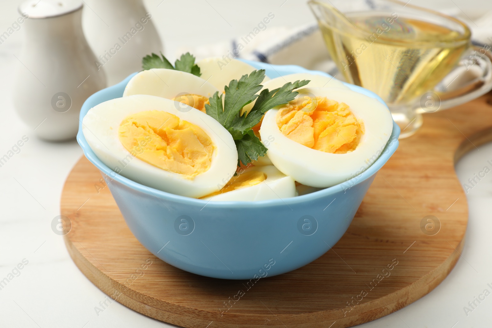 Boiled eggs, parsley and oil on white table, closeup Photo of Boiled eggs, parsley and oil on white table, closeup